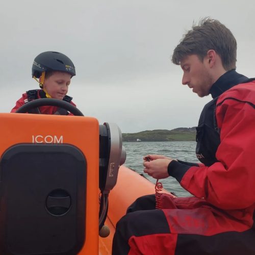 Zach getting instruction on the Club Safety Boat during his water sports intro